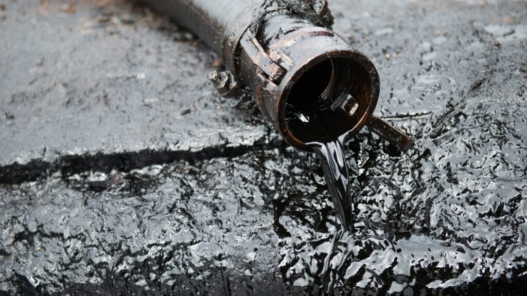 Heavy oil sludge discharging from a pipe outlet